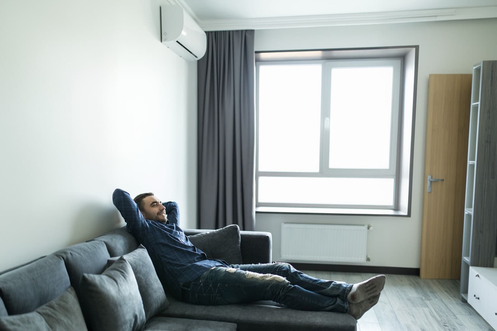 Homme détendu sur un canapé dans un salon climatisé