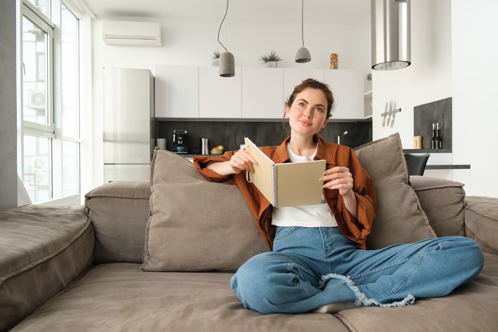 Femme assise sur un canapé dans un salon confortable