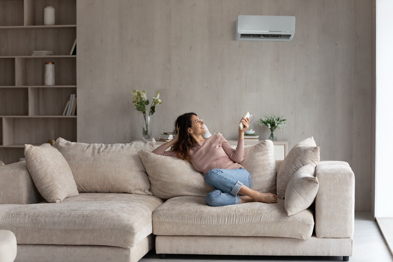 Femme détendue dans un salon équipé d’une thermopompe murale