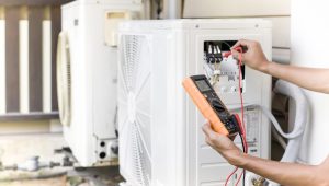 Air conditioner repairman using electricity meter to check air conditioner operation, maintenance concept